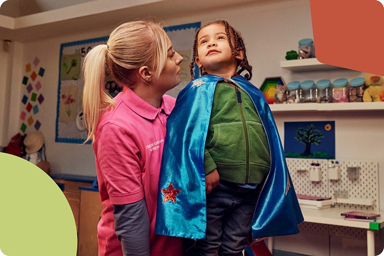 A woman looking closely at a dressed-up child in a blue cape staring heroically at the ceiling.