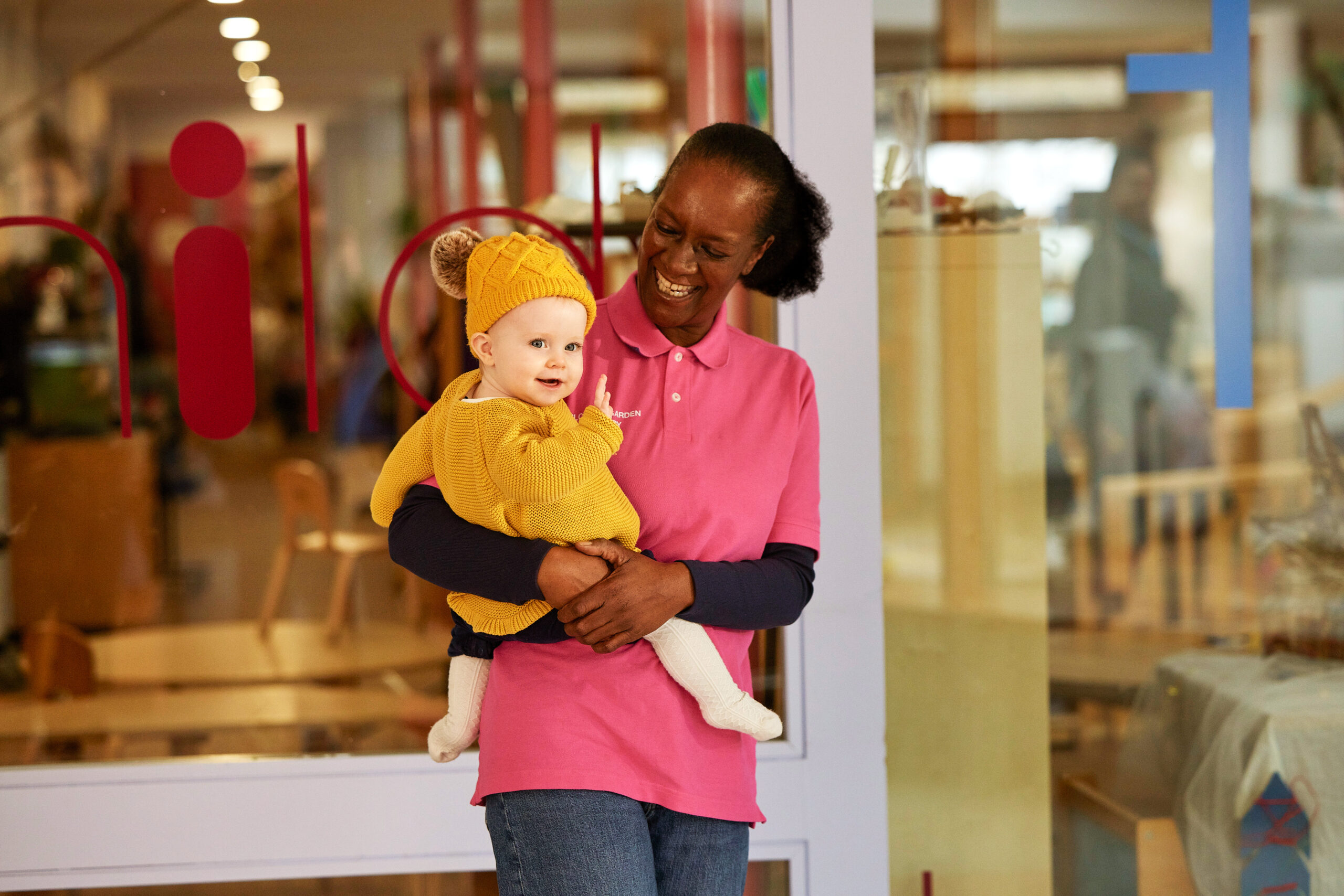 A smiling woman holding a baby.